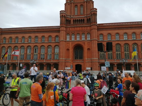 Demoteilnehmer und Redner Stefan Lehmkühler auf der Bühne, im. Hintergrund das Rote Rathaus Berlin. 